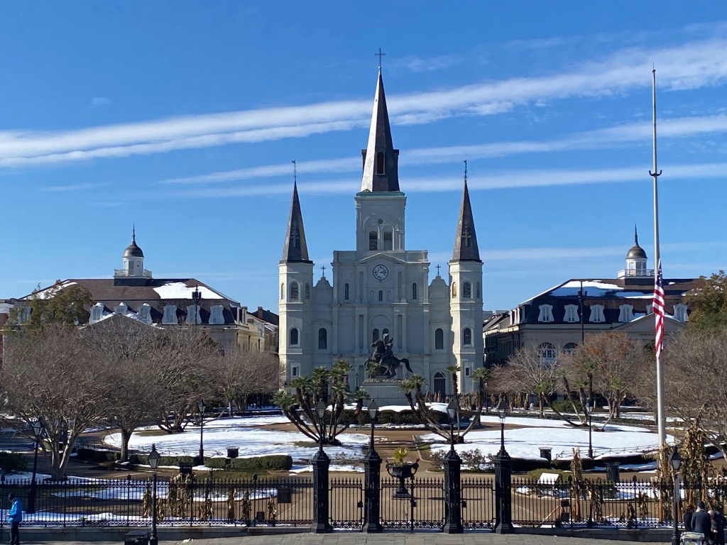 A photograph of Jackson Square and St. Louis Cathedral on a sunny day, the ground covered in large patches of snow.