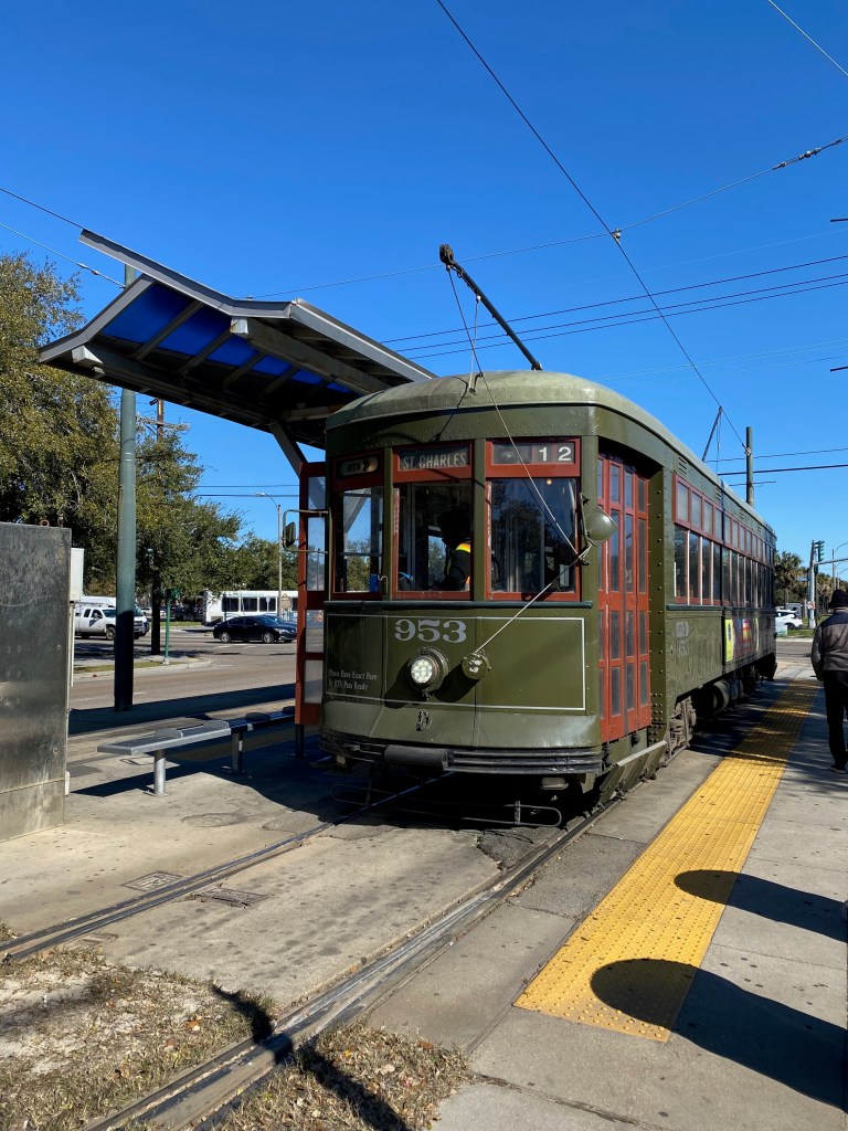 An old-fashioned streetcar, painted green with the nameplate "St. Charles" on its front.