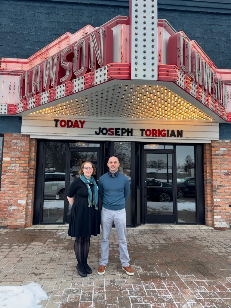 A woman and man stand in front of a movie-theater marquee that reads "Today: Joseph Torigian"
