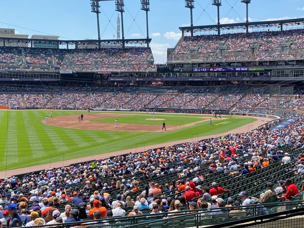 Photograph of a baseball game being played in a large stadium on a sunny day